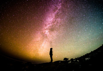 standing man watching star at night